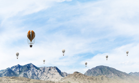 Beautiful nature landscape with flying balloons among high mountains and cloudly skyscape. 3D rendering.の写真素材