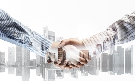 Close of business people shaking hands as symbol for partnership. Mixed mediaの写真素材