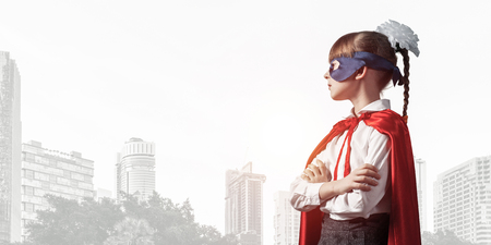 Little confident child in mask and cape plays cool superheroの写真素材