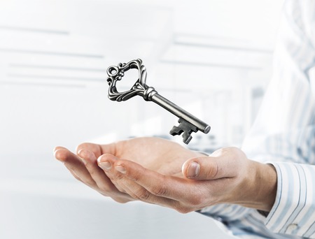 Close up of businessman hands holding old key as symbo for success. Mixed mediaの写真素材