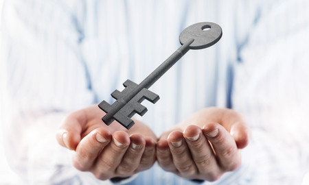 Cropped image of businessman in suit keeping stone key symbol in hands. Mixed mediaの写真素材