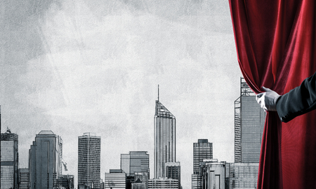 Close up of hand in white glove open red velvet curtain and construction model on wallの写真素材