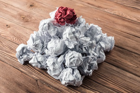 White crumpled up piece of paper on wooden table as idea