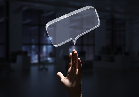 Close of businessman hands touching glass speech bubble as internet concept. Mixed mediaの写真素材
