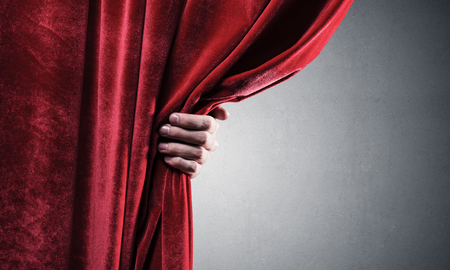 Close up of businessman hand open red velvet curtain. Place your textの写真素材