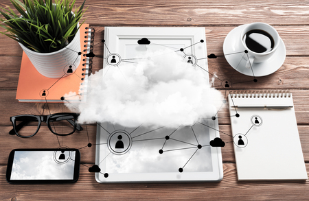 Top view of modern workplace with office stuff, social network connections and clouds above as symbol of still office life. Mixed media.の写真素材