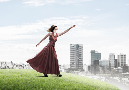 Young attractive woman relaxing in summer day against cityscape backgroundの写真素材