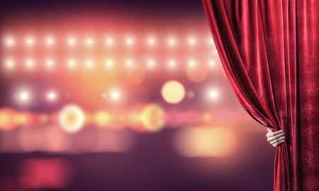 Close up of businessman hand open red velvet curtain of stageの写真素材