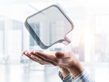Close of businessman hands showing glass speech bubble as internet concept. Mixed mediaの写真素材