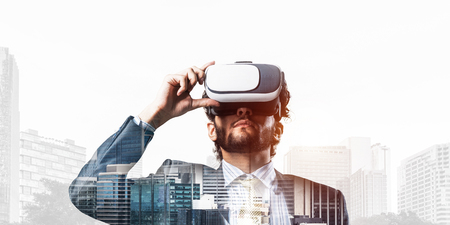Double exposure of businessman in virtual helmet against cityscape backgroundの写真素材