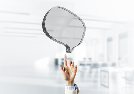 Close of businessman hands touching glass speech bubble as internet concept. Mixed mediaの写真素材