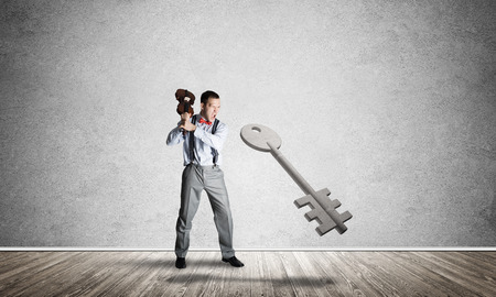 Determined businessman in concrete interior breaking with violin stone key figureの写真素材