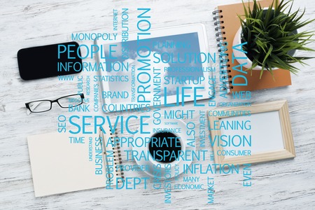 Top view of modern workplace with office stuff and business-related terms above presenting still office lifeの写真素材