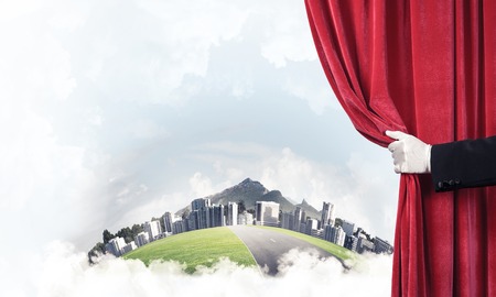 Close up of hand in white glove open red velvet curtainの写真素材