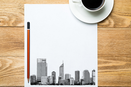 Wooden table with coffee cup and architectural sketches on notepadの写真素材