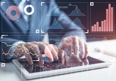 Stockbroker working with financial information at tablet computer. Interactive stock market tracking graph, trading indicators and exchange indexes. Global financial investment and trading conceptの写真素材