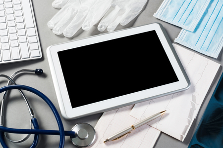 High angle shot of tablet and medical items on gray surfaceの写真素材
