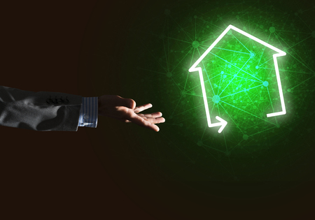 Hand of businessman touching with finger glowing home icon or symbolの写真素材