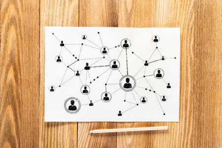 Human resource management pencil hand drawn with human icons and intersections. Business recruitment sketch on wooden surface. Top view of workplace with white paper and pencil lying on wooden deskの写真素材