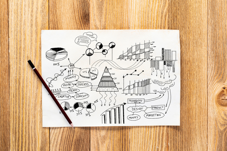 Money management and financial chart pencil hand drawn with group of business doodles. Workplace with paper and pencil lying on wooden desk. Business presentation. Finance and investment conceptの写真素材