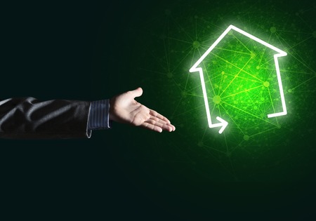 Hand of businessman touching with finger glowing home icon or symbolの写真素材