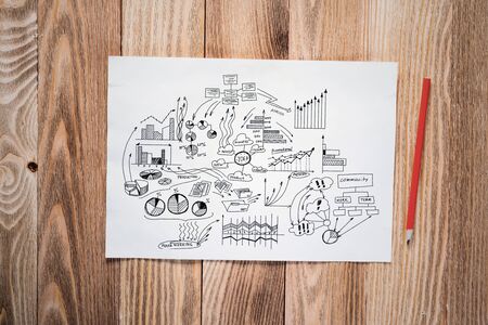 Money management and financial chart pencil hand drawn with group of business doodles. Workplace with paper and pencil lying on wooden desk. Business presentation. Finance and investment conceptの写真素材