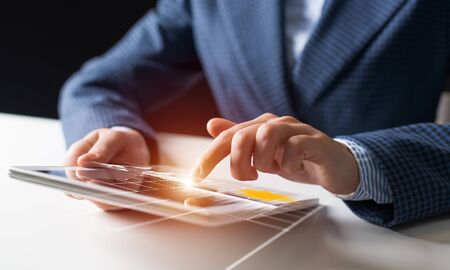 Businessman hands using tablet computer. Digital marketing media or financial diagrams in virtual...