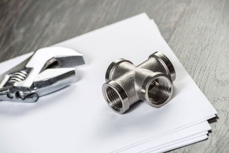 Plumbing pipeline connector laying on table. House water system planning and montage service. Steel...
