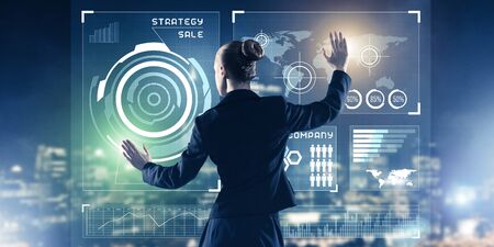 Back view of businesswoman working with virtual panel and night city at backgroundの写真素材