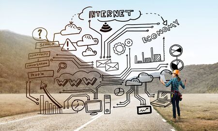 Back view of engineer woman in hardhat outdoor and sketched concept on screenの写真素材