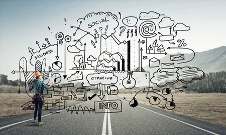 Back view of engineer woman in hardhat outdoor and sketched concept on screenの写真素材