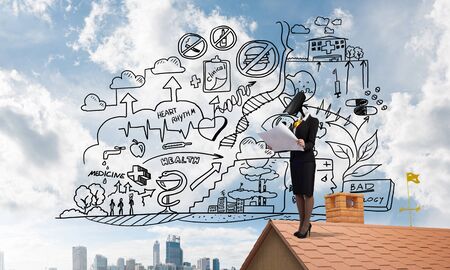 Faceless businesswoman with camera zoom instead of head standing on house roofの写真素材