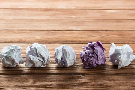 White crumpled up piece of paper on wooden table as ideaの写真素材