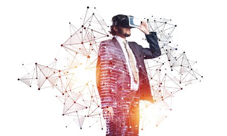 Businessman wearing VR headset using futuristic interface. Mixed media with 3d objects. Business model simulation and management. Mixed media with 3d objects. Social network connection modelの写真素材