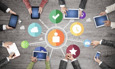 Group of people with devices in hands working together as symbol of networking and communicationの写真素材