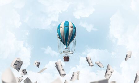 Colorful aerostat flying among paper documents and over the blue cloudy sky. 3D rendering.の写真素材