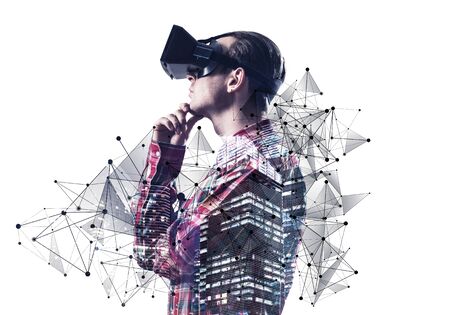 Young man exploring virtual world, interacting with digital interface. Guy wearing VR goggles and gesturing in air. Studio photo by side view man against white background. New cyber reality conceptの写真素材