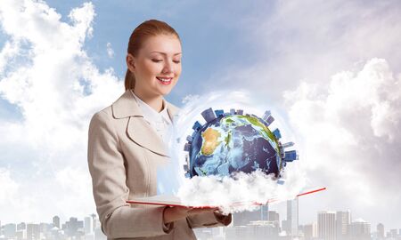 Smiling woman looking at earth globe above open book. Global business concept. Elegant young woman...