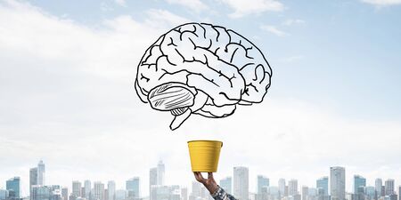 Brain drawing flying above yellow pot. Human hand holding pot with brain on modern cityscape...