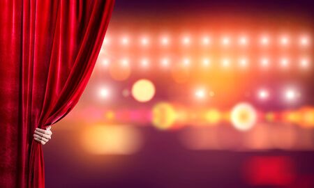 Close up of businessman hand open red velvet curtain of stageの写真素材