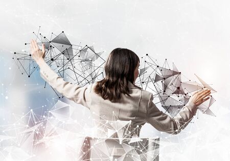 Businesswoman controlling and managing abstract network structure. Back view long haired woman in white suit sitting on white chair. Social connection and networking. Global cloud technology conceptの写真素材