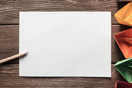White paper sheet and pencil on wooden table as concept for new idea