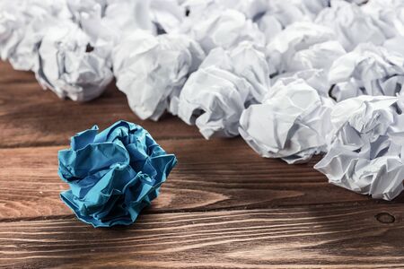 White crumpled up piece of paper on wooden table as ideaの写真素材