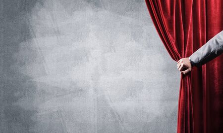 Close up of businessman hand open red velvet curtain. Place your textの写真素材