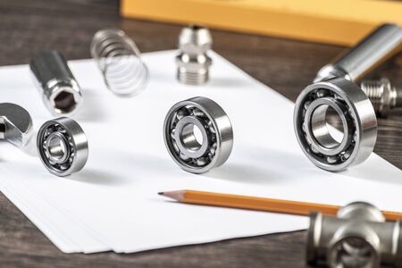 Three various ball bearings lying on table. Automotive spare part sale company. Heavy industry engineering company. Machinery designing and manufacturing. Steel details for engine mechanisms.の写真素材