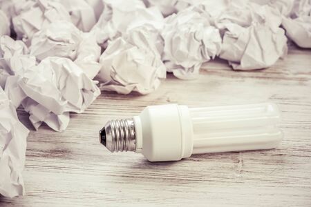 Many balls of crumpled paper and light bulb among themの写真素材