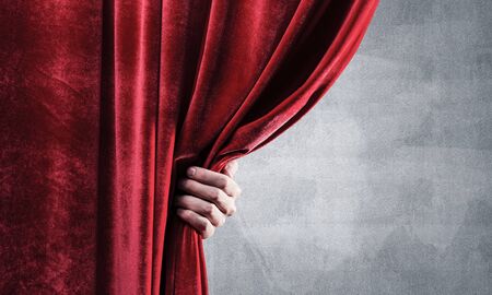 Close up of businessman hand open red velvet curtain. Place your textの写真素材