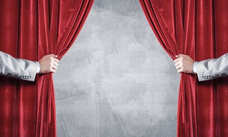 Close up of businessman hand open red velvet curtain. Place your textの写真素材