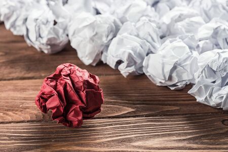 White crumpled up piece of paper on wooden table as ideaの写真素材
