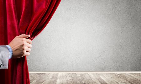 Close up of businessman hand open red velvet curtain. Place your textの写真素材